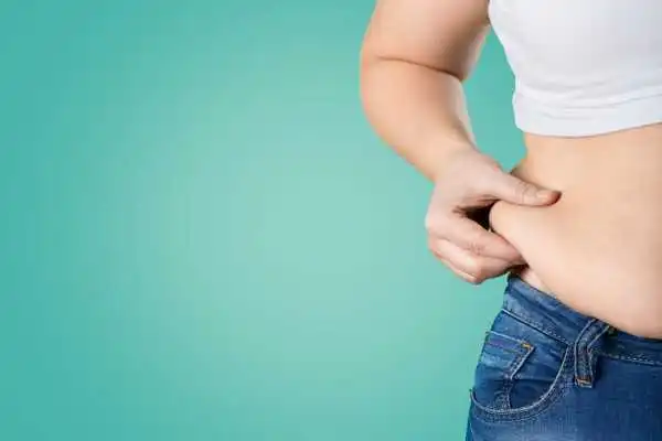 Image of woman pinching her love handles to show weight gain Craigmillar